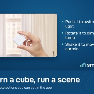 A hand holding the Aqara Cube in front of a window with curtains