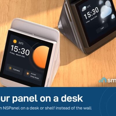 Two Sonoff NSPanel screens showing the time, standing on a wooden desk in Sonoff desk stands