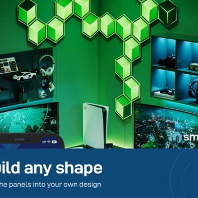 Green Govee Glide Hexagon panels arranged in a custom shape on the wall of a gaming room