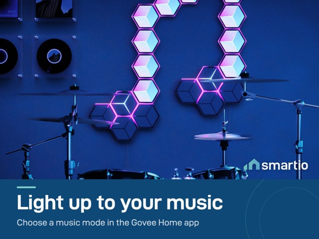 Govee Glide Hexagon panels in pink and white on a wall above a drum kit