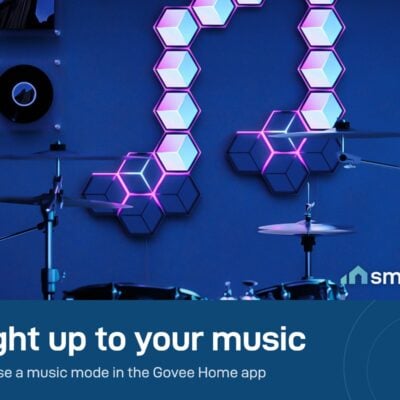 Govee Glide Hexagon panels in pink and white on a wall above a drum kit