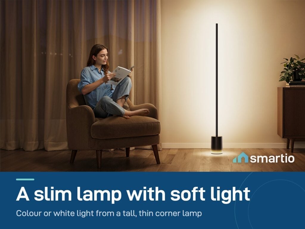 Govee Floor Lamp 2 giving warm light beside a woman reading in an armchair