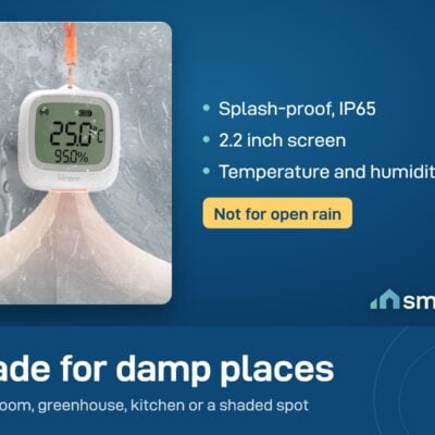 Sonoff SNZB-02WD IP65 LCD thermometer hanging on a wall while water splashes it. It is splash-proof, not for open rain