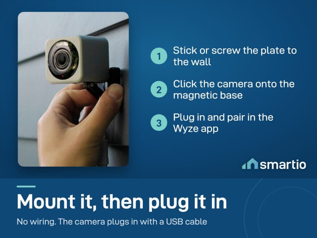 A hand fitting the Wyze Cam v4 onto its magnetic mount on an outside wall
