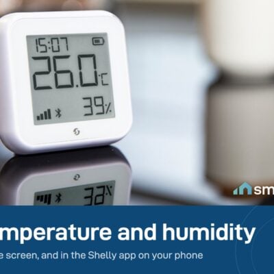 Shelly H&T Gen3 sensor on a desk showing 26 degrees and 39 percent humidity on its e-paper screen