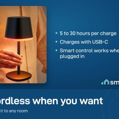 A hand lifting the Govee Cordless Smart Table Lamp Classic by its rod, glowing orange