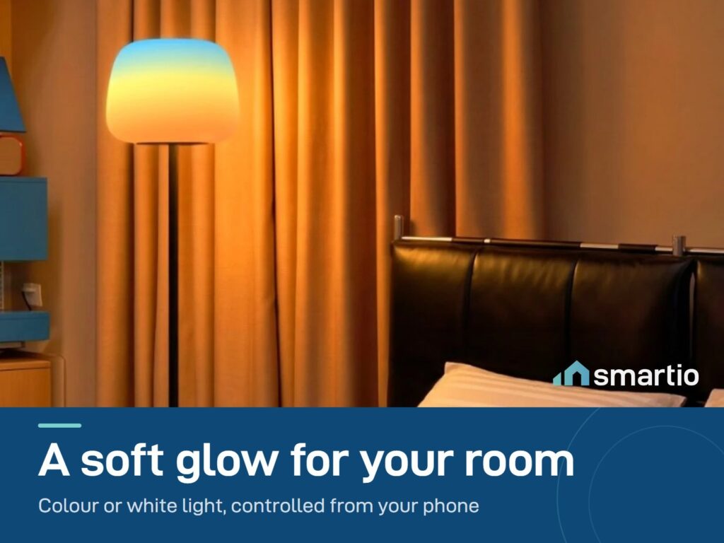 Govee floor lamp glowing warm orange beside a bed in a bedroom