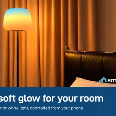 Govee floor lamp glowing warm orange beside a bed in a bedroom